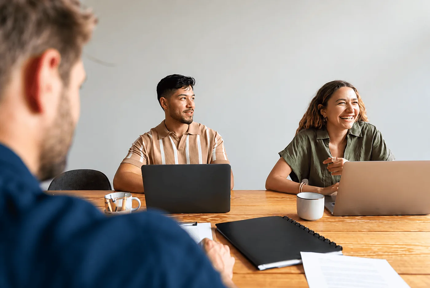 A friendly client meeting around a table with laptops and coffee